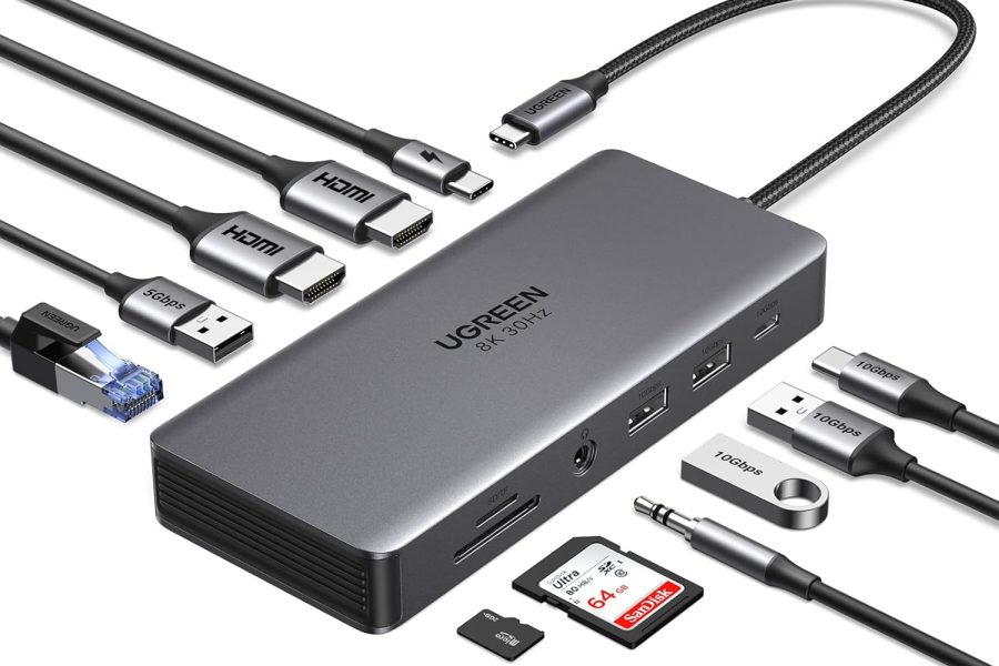 A Ugreen Revodok Pro 313 USB-C hub with various cables and adapters connected or shown alongside it, including HDMI, USB-A, Ethernet, an audio jack, and an SD card.
