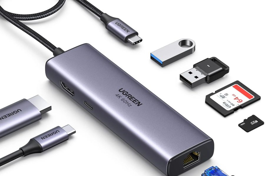 UGREEN space gray USB-C hub displaying multi-port connectivity, surrounded by a braided USB-C cable, HDMI connector, USB flash drives, full-size SD card, microSD card, and an Ethernet cable.